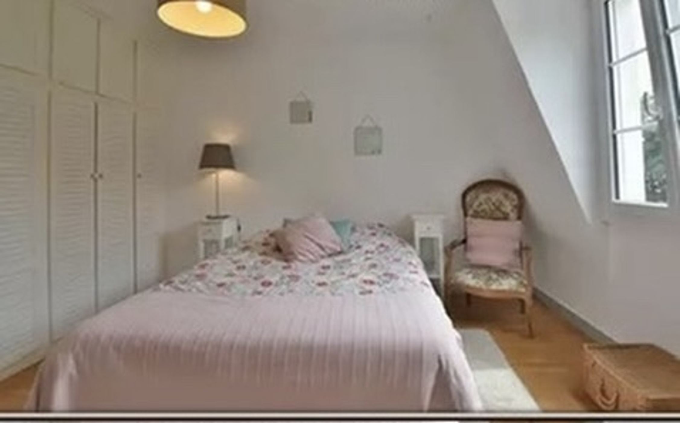 Chambre rénovée par Nouvel Espace — literie fleurie sous rampant