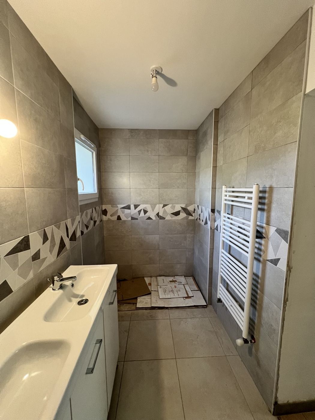 Salle de bain en cours de rénovation — faïence et sèche-serviettes posés